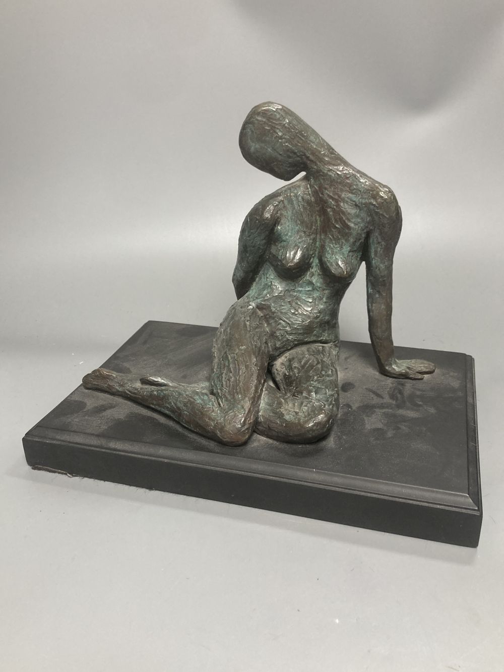 A contemporary bronze figure of a seated female figure, ebonised plinth 29.5cm wide